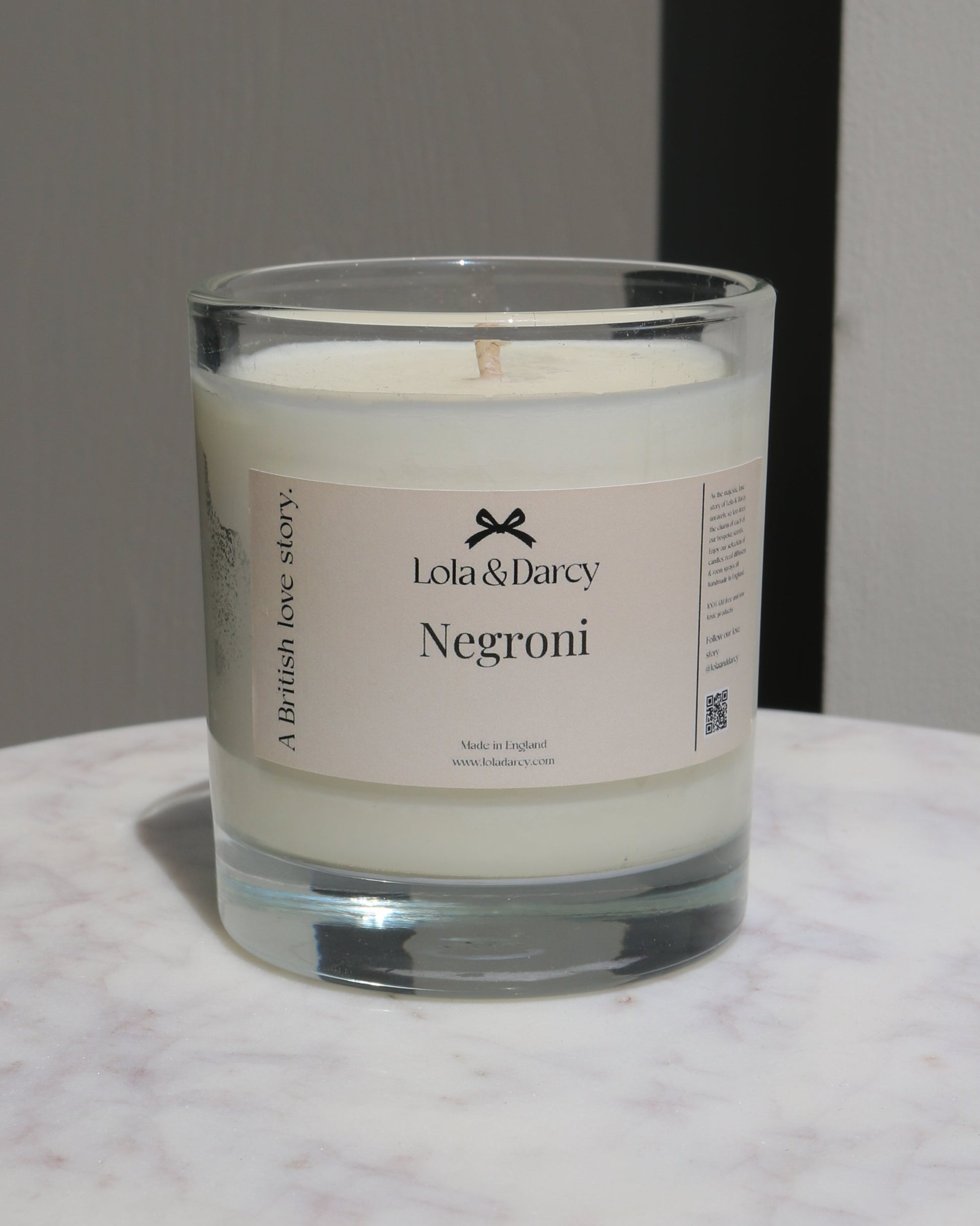 Candle in a glass jar with a label on a marble surface