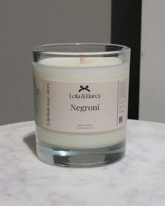 Candle in a glass jar with a label on a marble surface